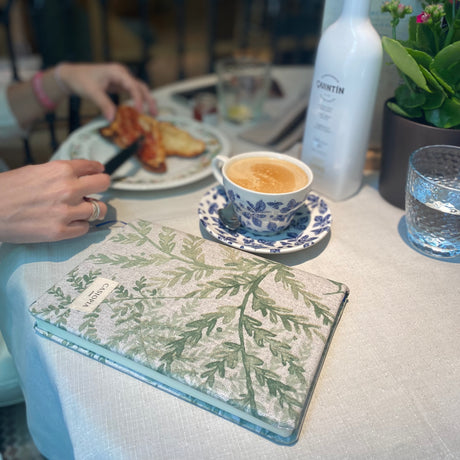 Agenda con tela antimanchas helechos, con un precioso diseño de hojas verdes sobre fondo beige de Casiopia ideal para regalo. En el interior dispone de hojas ralladas con espacio para fecha